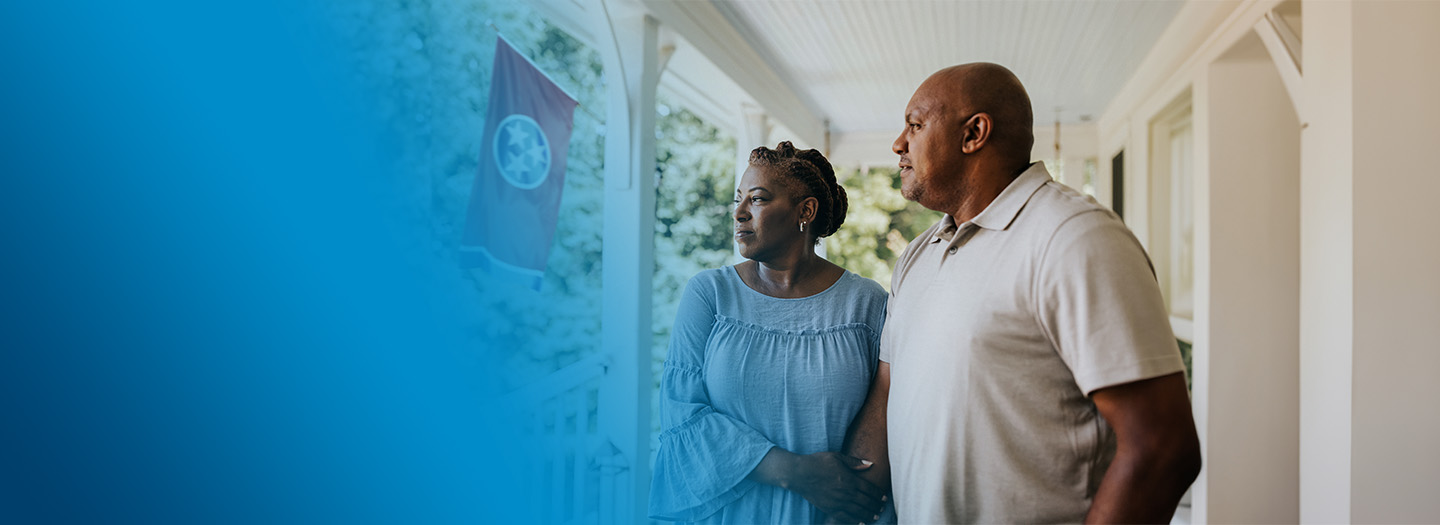 A senior couple enjoy a sunny day on their front porch.