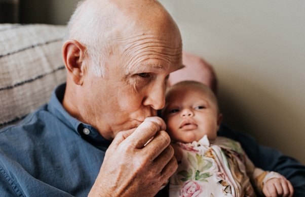 Grandfather kissing a small baby