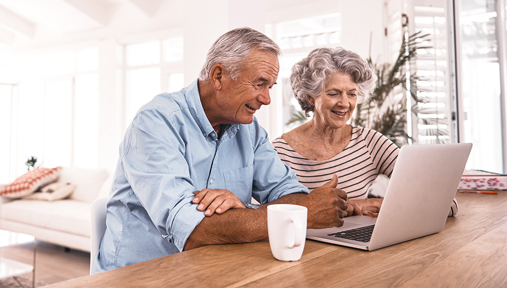 A senior couple enrolling in a plan on their laptop.