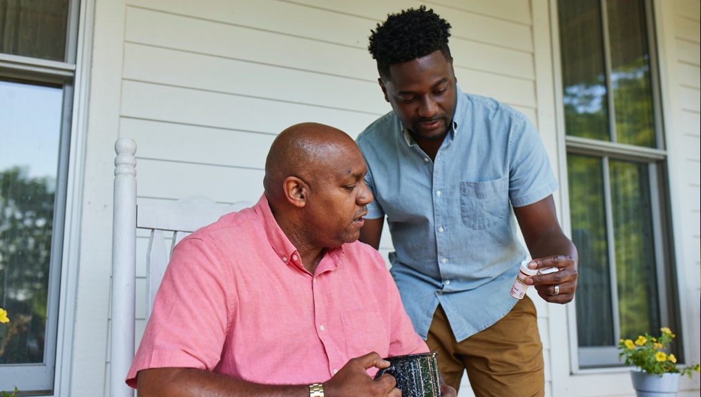 Father and son examining a prescription bottle Father and son examining a prescription bottle