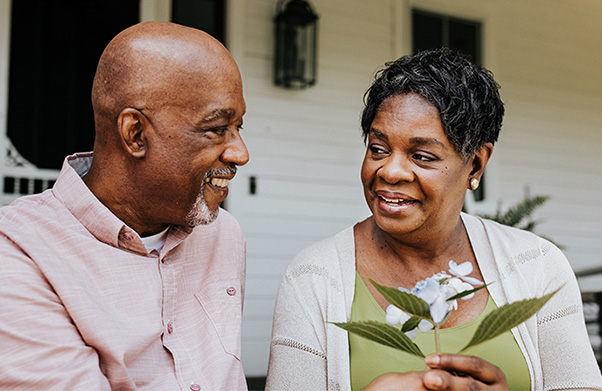 A husband giving his wife a flower.