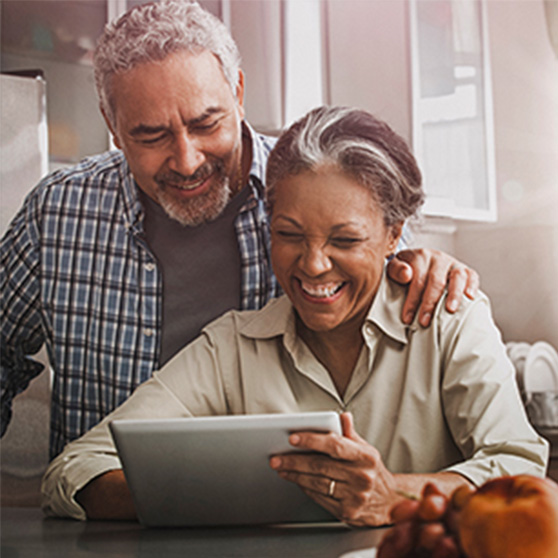 An older couple checking their MTM eligibility on their tablet.