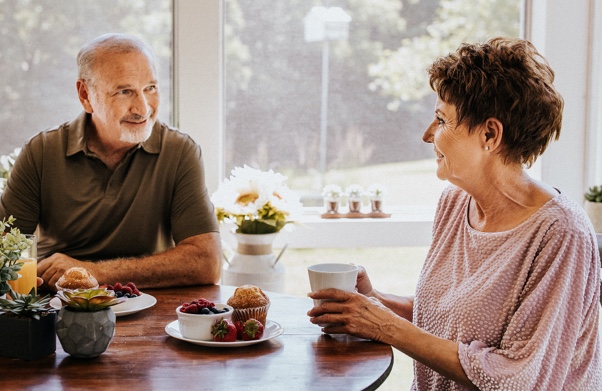 Older couple smiling over breakfast