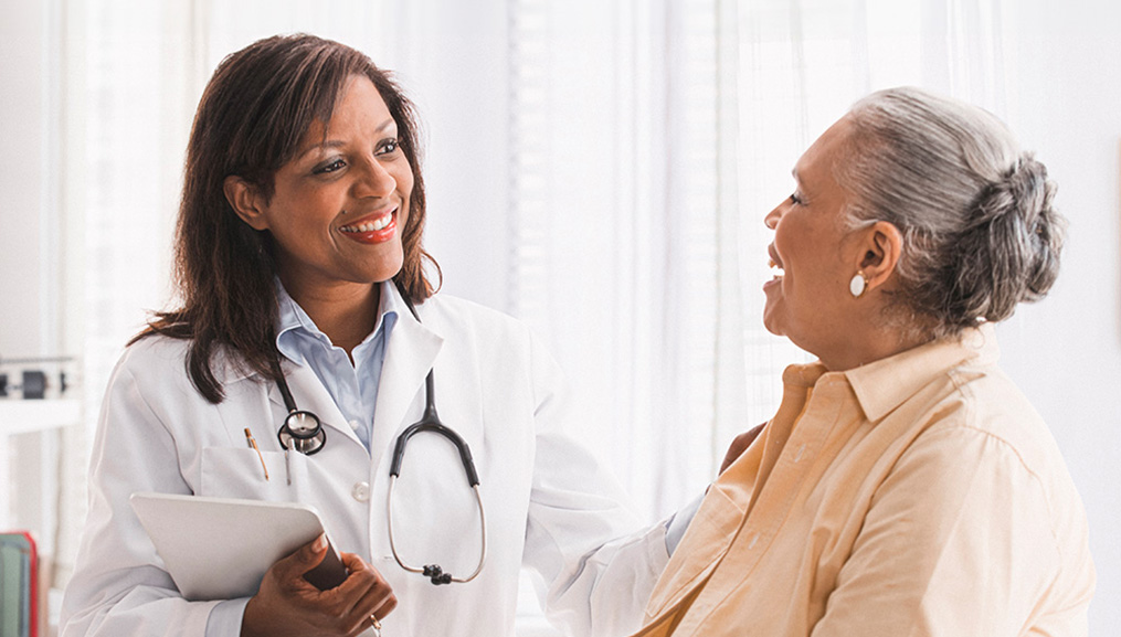 A doctor encourages her senior patient.