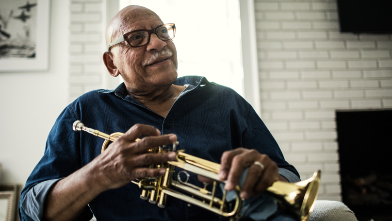 Older man seated and holding a trumpet | BCBS of Tennessee Older man seated and holding a trumpet | BCBS of Tennessee
