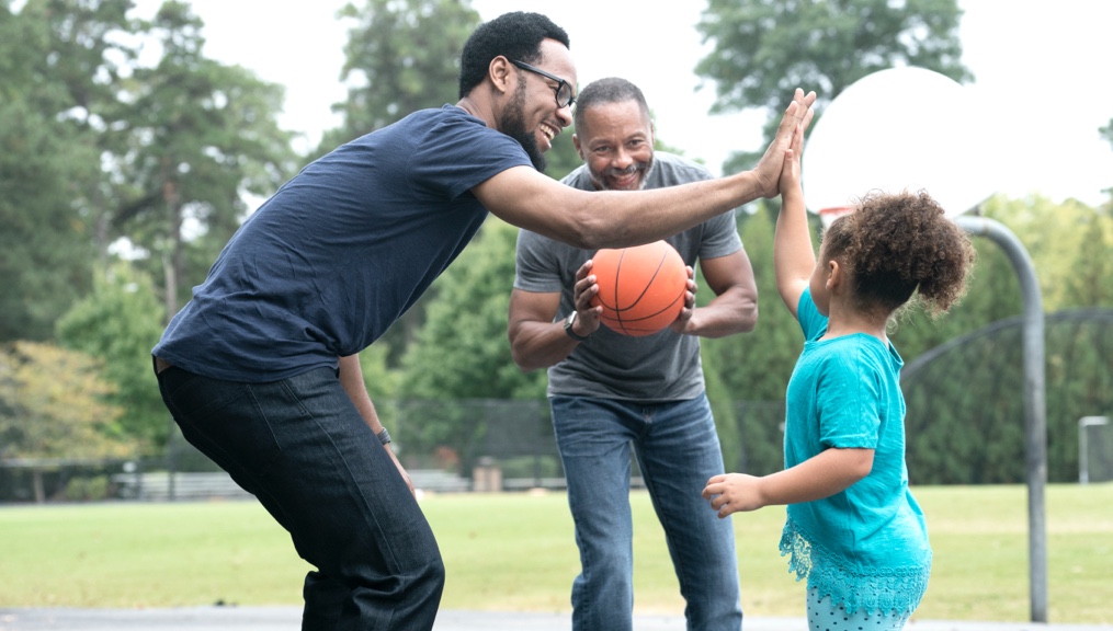Family playing basketball in the park