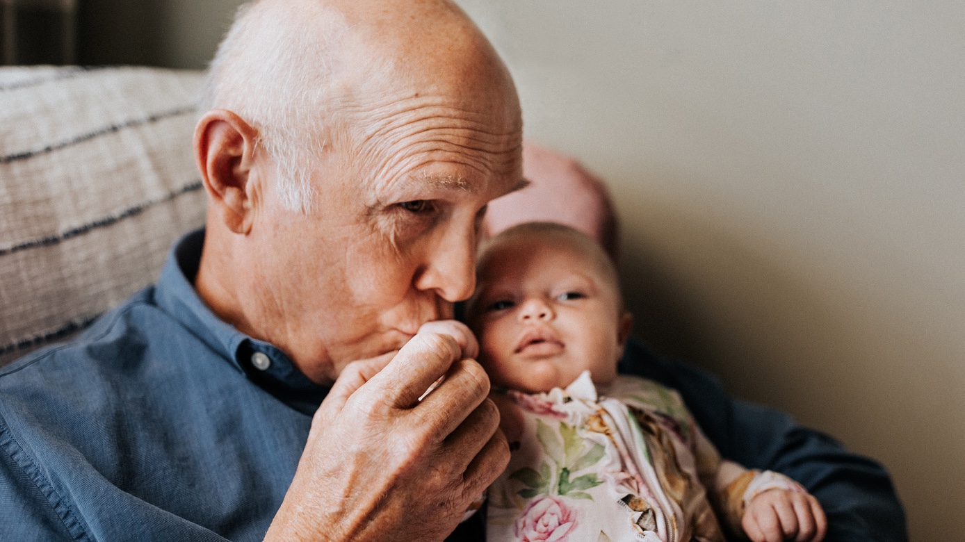 Grandfather kissing a small baby