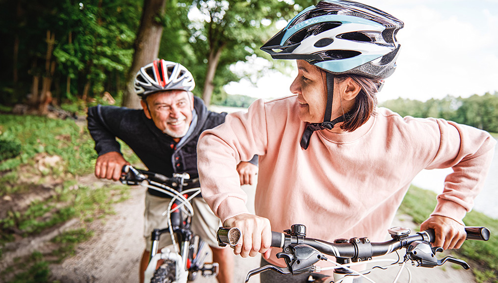 A senior man and woman going on a bike ride.