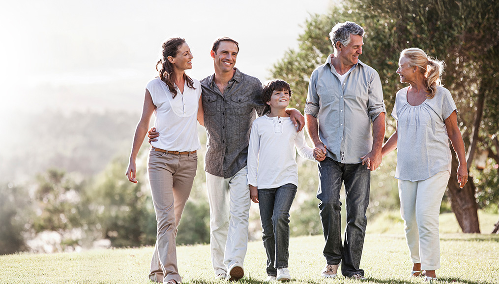 Child walking in a park with his parents and grandparents. Child walking in a park with his parents and grandparents.