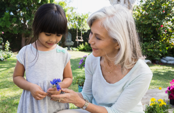 Grandmother showing a flower to her granddaughter | BCBS of Tennessee