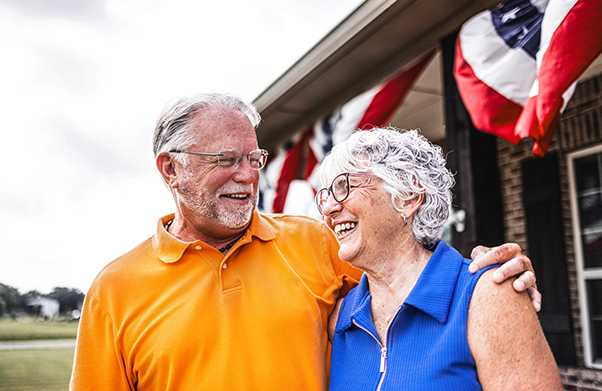Husband and wife standing in front of their house