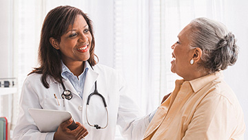 A doctor encourages her senior patient.