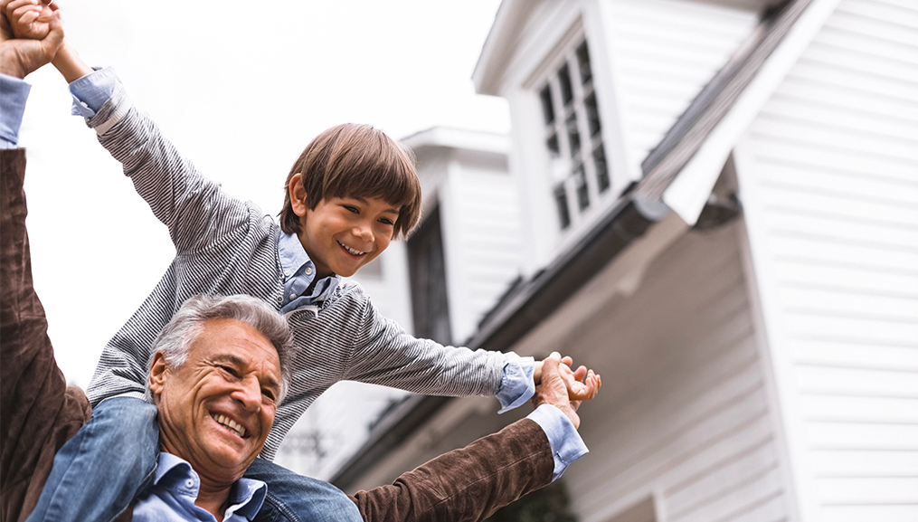 Grandfather carrying his grandson on his shoulders.