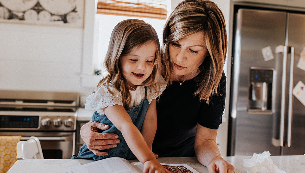A grandmother and her granddaughter cooking together in the kitchen.