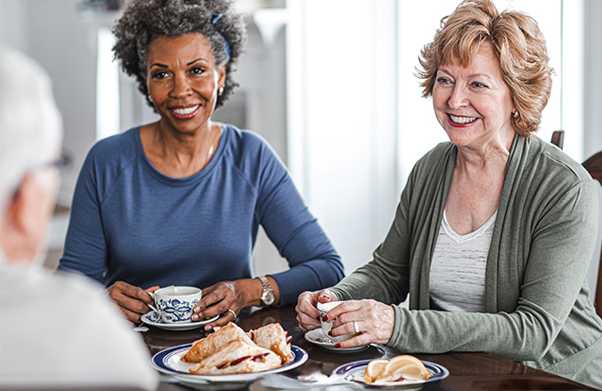 Two older women chatting over tea.